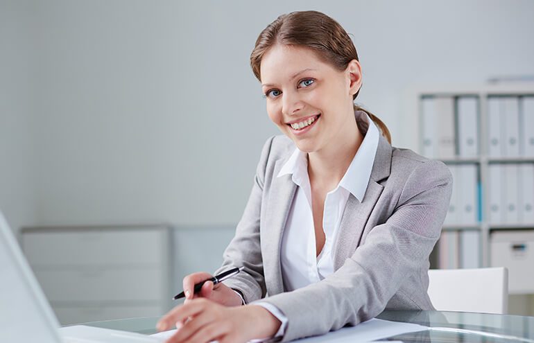 A professional woman in a gray blazer smiling at the camera. A professional woman in a gray blazer smiling at the camera.