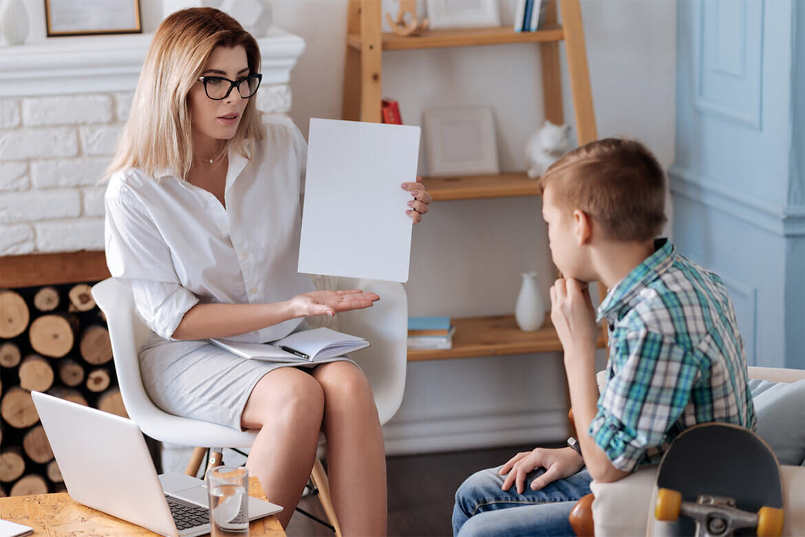 Teacher showing a blank sheet to a student in a classroom.