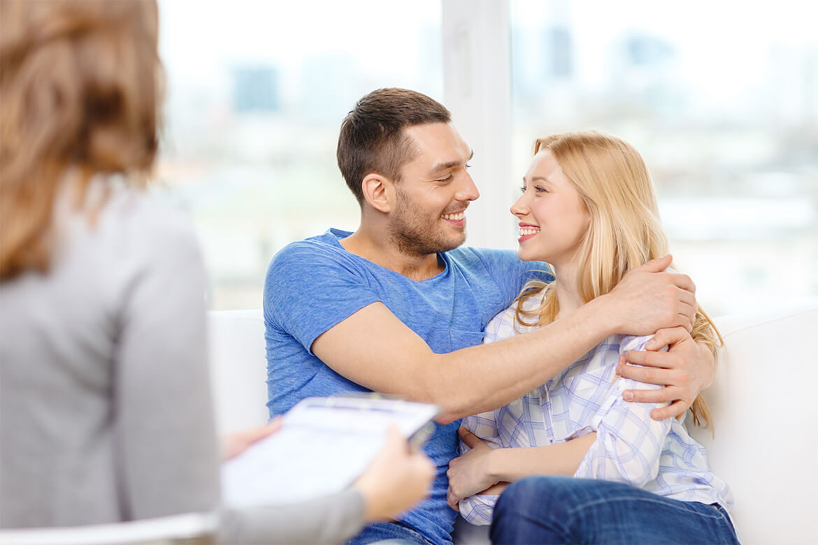 A couple happily embracing each other indoors.